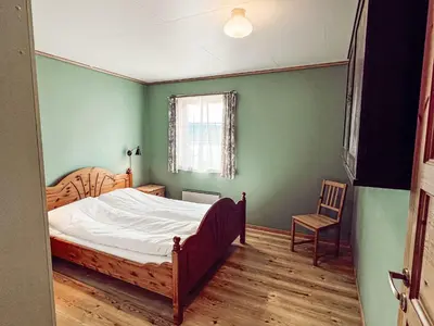 a bedroom with a bed and a chair in it at Holiday Home Pærehagen by Interhome in Balestrand