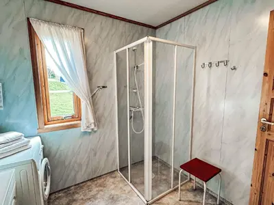 a shower with a red stool in a bathroom at Holiday Home Pærehagen by Interhome in Balestrand