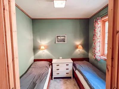 two beds in a bedroom with green walls at Holiday Home Pærehagen by Interhome in Balestrand