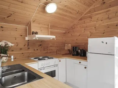 a kitchen with white appliances and wooden walls at Holiday Home Veganeset II by Interhome in Balestrand