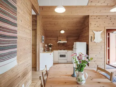 a kitchen with wooden walls and a table with flowers at Holiday Home Veganeset II by Interhome in Balestrand
