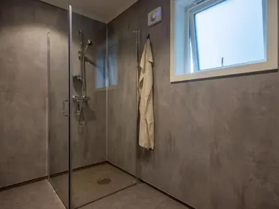 a shower with a glass door and a window at Holiday Home Pale by Interhome in Bømlo