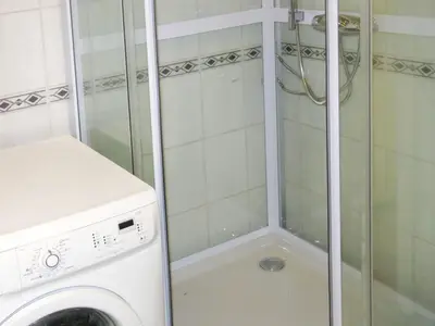 a shower with a glass door next to a washing machine at Holiday Home Nesjevik by Interhome in Bø