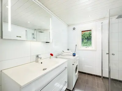 a white bathroom with a sink and a washing machine at Holiday Home Balder by Interhome in Arnefjord