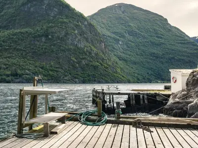 a dock on a lake with mountains in the background at Holiday Home Balder by Interhome in Arnefjord