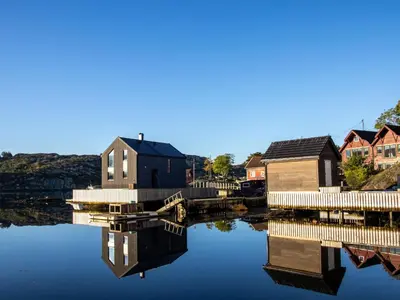 a house on a body of water with houses at Holiday Home Torsk by Interhome in Bømlo