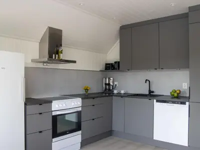 a kitchen with white appliances and gray cabinets at Holiday Home Torsk by Interhome in Bømlo