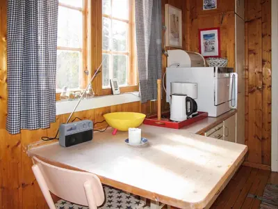a kitchen with a wooden table with a radio on it at Chalet Skeisvegen by Interhome in Svingvoll