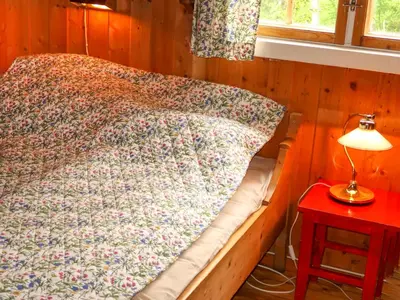 a bed in a room with a lamp on a table at Chalet Skeisvegen by Interhome in Svingvoll