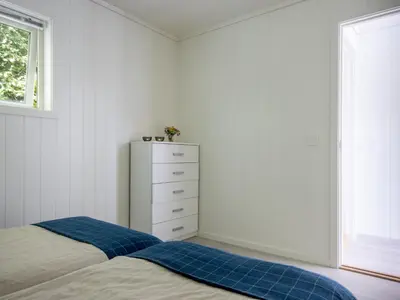 a bedroom with a bed and a dresser and a window at Holiday Home Lange by Interhome in Bømlo