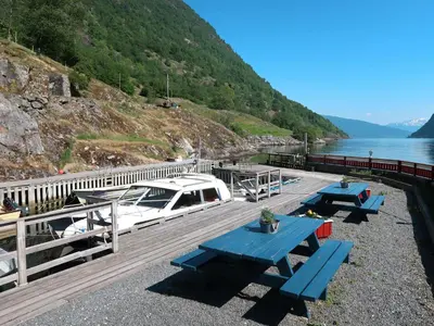 a dock with picnic tables and a boat on the water at Holiday Home Krokeggi by Interhome in Arnefjord