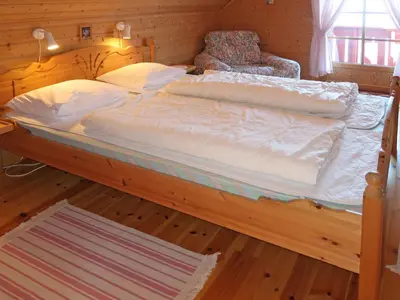 a large bed in a room with a wooden floor at Holiday Home Krokeggi by Interhome in Arnefjord