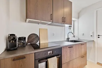 a kitchen with wooden cabinets and a sink at Luxury Suite in Charming Area in Bergen