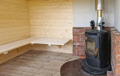 a sauna with a stove and a bench in it at 1 Bedroom Stunning Home In Haugesund in Haugesund