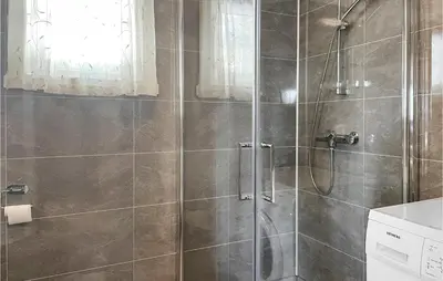 a bathroom with a shower with a glass door at 4 Bedroom Awesome Home In Engerdal in Nymoen