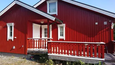 a red house with a porch and a white door at Matthias Hytte in Fevåg