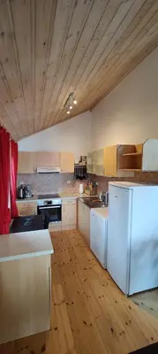 a kitchen with a white refrigerator and a wooden floor at Matthias Hytte in Fevåg