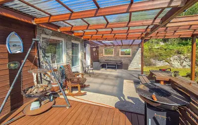 an outdoor deck with a pergola and a grill at Awesome Home In Sveio With Wifi in Sveio