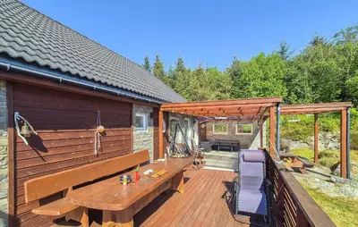 a wooden deck with a wooden table and chairs at Awesome Home In Sveio With Wifi in Sveio
