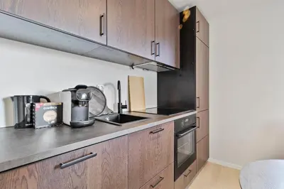 a kitchen with wooden cabinets and a sink at Exclusive Bergen Suite in Bergen