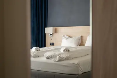 a bedroom with a bed with white sheets and pillows at BREEZE Hotel Victoria - Self-Service in Bergen