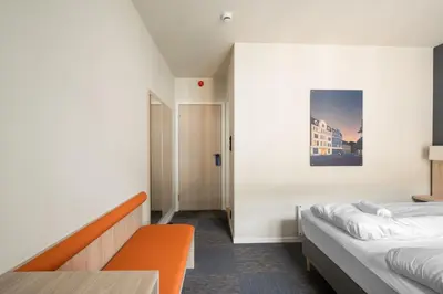 a hotel room with a bed and a table and a bed sidx sidx at BREEZE Hotel Victoria - Self-Service in Bergen