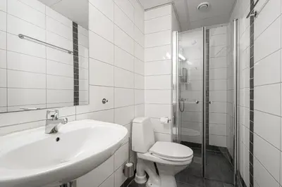 a bathroom with a toilet and a sink and a shower at BREEZE Hotel Victoria - Self-Service in Bergen