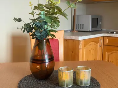 a vase with a plant in it on a table with two cups at Family-Friendly Apartment Close To Nature in Beitostøl