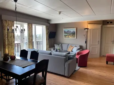 a living room with a couch and a table at Central Apartment With 3 Bedrooms And Balcony in Beitostøl