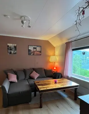 a living room with a couch and a table at Gulthus in Odda