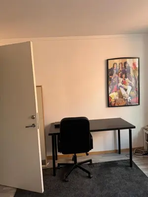 an office with a desk and a chair and a painting at Spacious and central apartment I 250m from Bryggen in Bergen