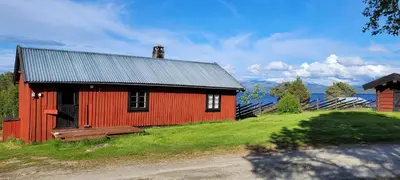 a red barn with a bench in front of it at Buviken Nordre, Femund in Sømådalen