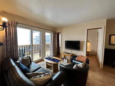 a living room with leather furniture and a large window at Family-Friendly Apartment Steps From Everything in Beitostøl
