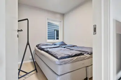 a small bedroom with a bed and a mirror at Premium Bergen Suite in Bergen