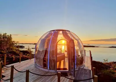 a glass dome sitting on top of a wooden deck at Atlantic Dome in Skotten