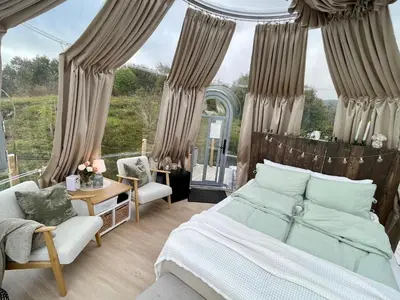 a bedroom with a bed and chairs and a window at Atlantic Dome in Skotten