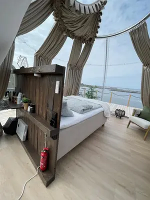 a bed in a room with a view of the ocean at Atlantic Dome in Skotten