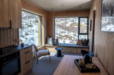 a kitchen with wood paneling and a large window at Filefjellstuene Hotel in Tyinkrysset