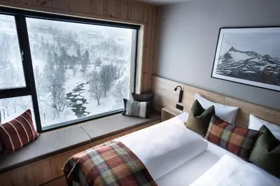 a bedroom with a bed and a large window at Filefjellstuene Hotel in Tyinkrysset