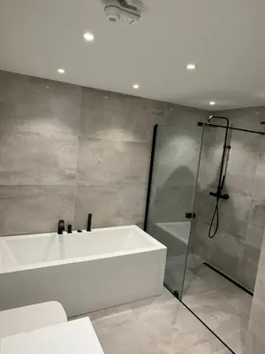 a bathroom with a white tub and a shower at Villa med fantastisk uteplass! 10 sengeplasser! in Ålesund