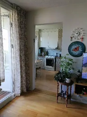a living room with a kitchen and a table with a plant at Leilighet nær Trondheim in Trondheim