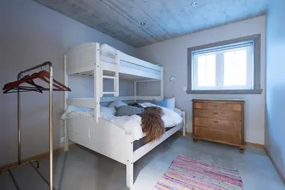 a bedroom with a white bunk bed and a dresser at Spacious Mountain Lodge Stryn in Stryn