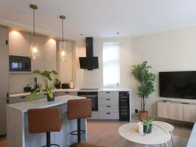 a living room with a kitchen with a table and chairs at Celestial Bergen Central Apartment in Bergen