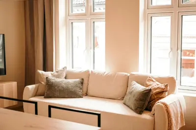 a living room with a couch with pillows on it at Celestial Bergen Central Apartment in Bergen