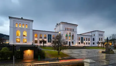 a large white building with its lights on at Celestial Bergen Central Apartment in Bergen