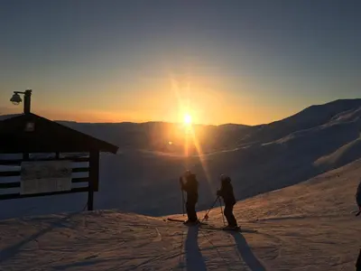 two people standing at the top of a ski slope at sunset at Voss-Oppheim Resort appartment witc acess to swimmingpool in Øyjordi