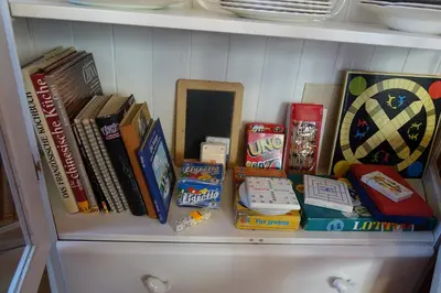 a shelf with books and other items on it at Guesthouse Hamran in Mosvik