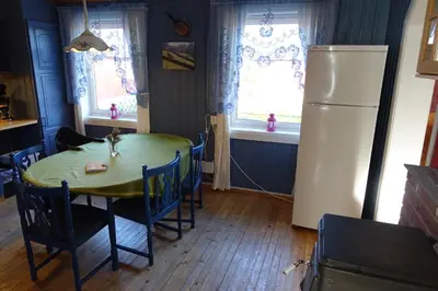 a kitchen with a table and a refrigerator at Guesthouse Hamran in Mosvik