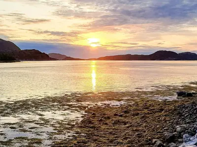 a sunset over a body of water with mountains at 6 person holiday home in Flatanger in Lauvsnes
