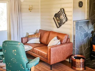 a living room with a couch and a chair at 6 person holiday home in Flatanger in Lauvsnes